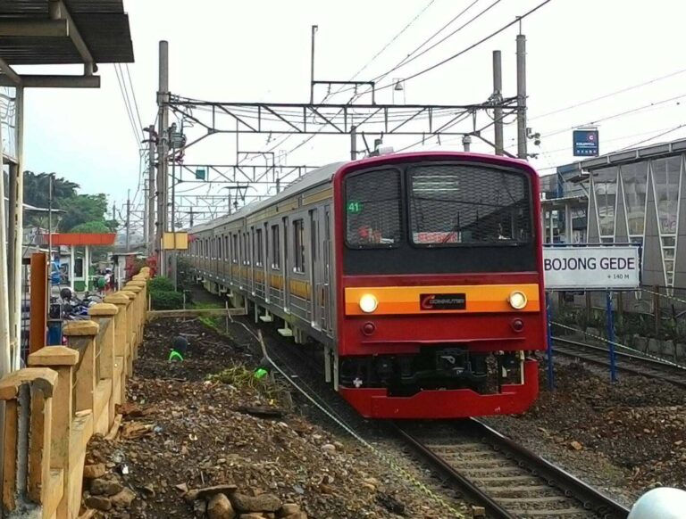 KRL seri 205 formasi 12 kereta melintasi area pekerjaan penambahan peron sisi selatan di stasiun Bojonggede
