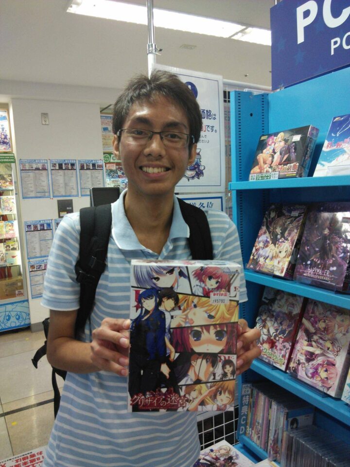 Memegang boks novel visual bekas dari seri Grisaia no Meikyuu. 